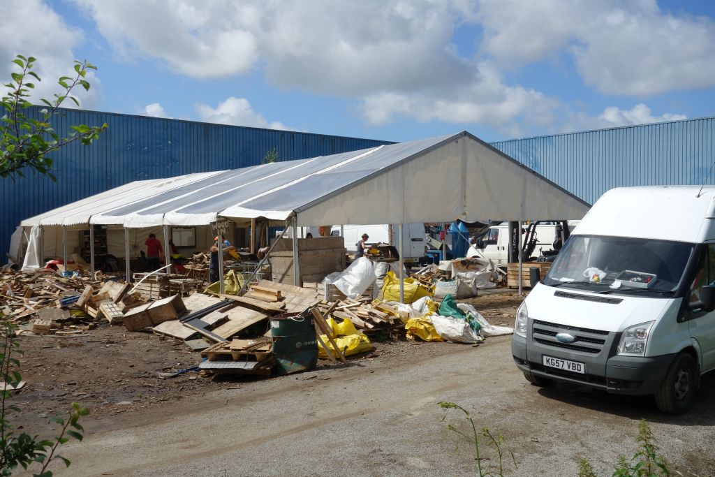 Le hangar découpe du bois pour faire du bois de chauffage pour les migrants